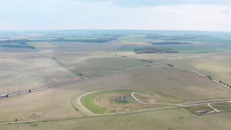 High-circling-drone-shot-of-Stonehenge-near-A303-highway-UK