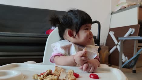 Asian-Cute-Baby-Girl-Eating-Her-Homemade-Food-On-Baby-Feeding-Chair
