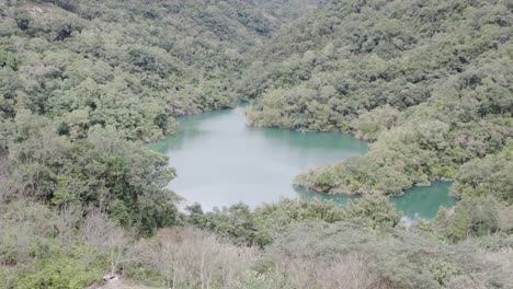 Ascending-tilting-camera-view-of-Spectacular-View-of-Feitsui-Reservoir,-Emerald-lake,-Thousand-Island-Lake-is-Second-largest-water-reservoir-dam-water-supply-in-Taiwan