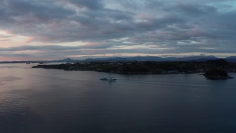 Fishing-vessel-and-cargoship-meets-in-Norway-fjord-Leroyosen-during-beautiful-sunset