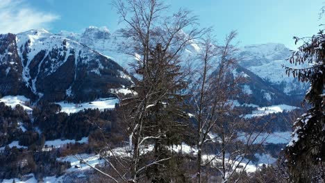 Increíble-Vuelo-De-Drones-De-Un-Impresionante-Valle-Alpino,-Pueblo-Y-Picos-Montañosos-Cubiertos-De-Nieve-En-Champery,-Suiza
