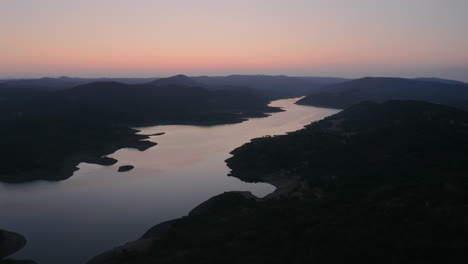 Drohne-Fliegt-Bei-Sonnenaufgang-über-Einen-Großen-Fluss-Und-Zeigt-Seine-Wirklich-Atemberaubende-Berg--Und-Flusslandschaft-Mit-Einem-Orangefarbenen-Hintergrund,-Spanien