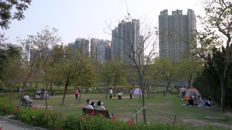 Paare-Und-Familien-Ruhen-Sich-Aus-Und-Genießen-Ihren-Abend,-Während-Die-Sonne-Untergeht,-Während-Sie-Sich-Im-Freien-In-Einem-Park-Versammeln-Und-In-Hongkong-Soziale-Distanz-Wahren