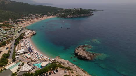 Vacation-spot-in-Mediterranean-coastline-of-Albania,-turquoise-seawater-and-sandy-beaches-near-resorts