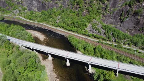 Highway-E16-between-Bergen-and-Oslo-Norway---Bridge-crossing-river-at-Dalekvam-at-a-bright-sunny-daywith-Bergen-railway-in-background---Aerial-with-no-cars-or-people