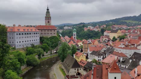 view-of-a-castle-in-Cesky-Krumlov-and-Vltava-river-with-paddlers,-tilt-up