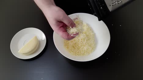 Hand-Des-Küchenchefs,-Der-Käse-Auf-Teller-Reibt