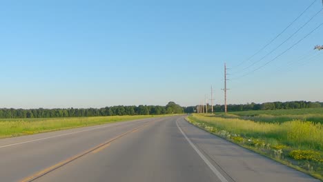 Pov-Mientras-Conduce-Por-Una-Carretera-Rural-Del-Condado-A-Través-Del-Medio-Oeste-En-Una-Tarde-De-Primavera