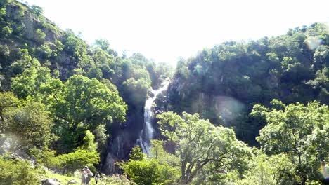People-discovering-Aber-falls-Snowdonia-mountain-Welsh-national-park-waterfall