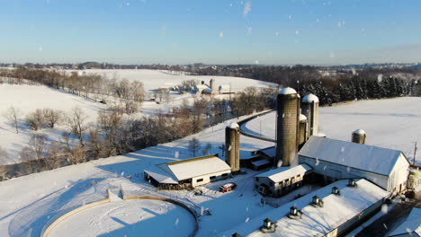 AERIAL-Snow-Falling-Over-Farm-Buildings-And-Silos