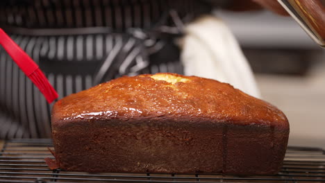 Brushing-a-sweet-glaze-on-a-lemon-pound-cake-fresh-out-of-the-oven