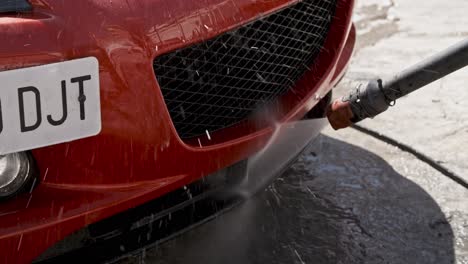 Pressure-washing-beautiful-red-Mazda-RX8-in-close-up-view