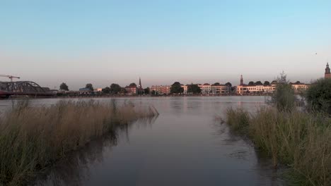 Water-filled-floodplains-of-the-river-IJssel-during-extreme-high-water-levels-with-panorama-of-Dutch-tower-town-Zutphen-in-The-Netherlands