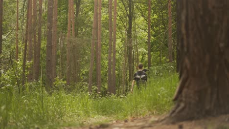 Male-videographer-filming-with-gimbal,-outdoor-forest-nature-video-shoot-scenery