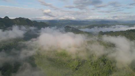 Die-Drohne-Bewegt-Sich-In-Richtung-Eines-Bewölkten-Berges,-Wobei-Der-Sonnenaufgang-Auf-Der-Wolke-Leuchtet