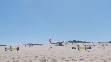Pocos-Grupos-De-Surfistas-Llevando-Sus-Tablas-De-Surf-En-Praia-Do-Guincho,-Portugal