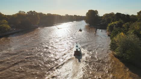 Speedboat-And-Wooden-Tourist-Boat-Sailing-At-Lujan-River-On-A-Sunny-Day-In-Tigre,-Buenos-Aires,-Argentina