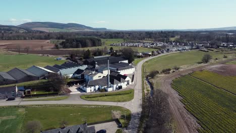 Aerial-view-of-Fettercairn-whisky-distillery-on-a-sunny-spring-day,-Aberdeenshire,-Scotland