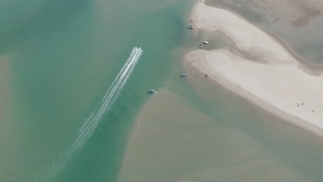 Aerial-top-down-view-of-a-high-speed-boat-chase-jet-ski-in-clear-sea-water