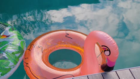 Vacation-travel-concept-with-inflatable-orange-flamingo-float-toy-mattress-in-luxury-swimming-pool