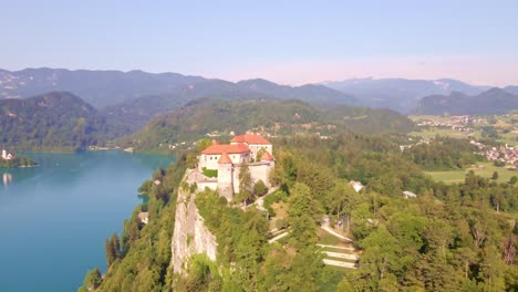 Point-of-interest-aerial-showcasing-Bled-Castle-high-above-Lake-Bled-and-the-surrounding-Julian-Alps-landscape-in-Slovenia