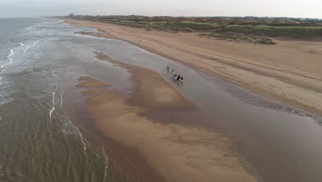 Scenic-View-Of-Tourist-Horseback-Riding-At-The-North-Sea-Beach-In-Netherlands