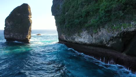 Aerial-view-of-turquoise-ocean-waves-crashing-cliffs-of-Nusa-penida-island,-one-of-the-tourist-attractions-of-Bali-island-Crystal-beach-kelingking-beach-angle-billabong-broken-beach