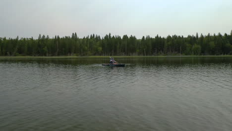 Hombre-En-Kayak-En-Un-Lago-Tranquilo-En-El-Bosque-Boreal,-Saskatchewan,-Canadá