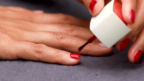 Woman-Painting-Nails-with-Red-Nail-Polish-Side-Shot