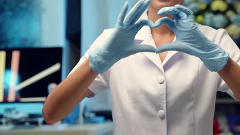 A-nurse-makes-a-heart-shaped-hand-sign-to-a-patient-as-a-kind-gesture