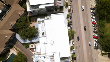 Aerial-birds-eye-view-traffic-through-urban-developing-area-in-big-city,-drone-4K