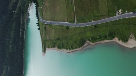 Aerial-above-road-along-shore-of-Frumoasa-Dam-reservoir