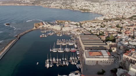 Harbor-with-boats-and-cityscape-of-Chania-city,-aerial-drone-view