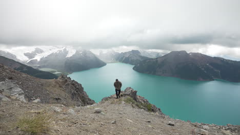 Man-On-Hilltop-With-Turquoise-Lake-At-Garibaldi-Provincial-Park-In-British-Columbia,-Canada