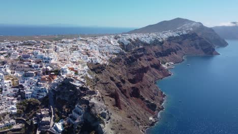 Flying-towards-white-houses-of-Santorini,-Greece
