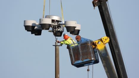 Men-At-Work-In-A-Bucket-Lift-Cutting-The-Cable-Of-An-Industrial-Highway-Lamp-Post-With-Damaged-Light-Bulbs-Due-To-An-Accident