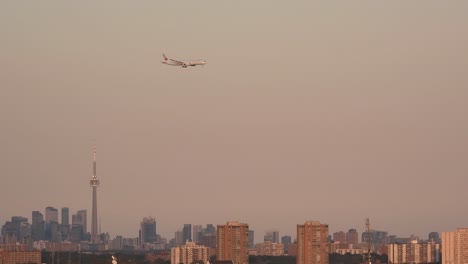 Passenger-plane-preparing-to-land-over-skyline-of-Toronto-city