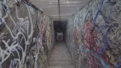 Tilt-down-view-of-a-graffiti-filled-staircase-to-basements