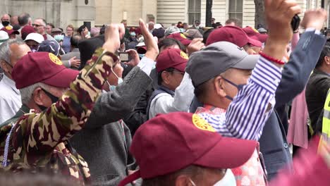 Eldery-Ghurka-veterans-in-maroon-baseball-caps-cheer-and-raise-their-fists-in-resistance-protest-opposite-Downing-Street-calling-for-full-military-pensions-for-all-Ghurka-veterans