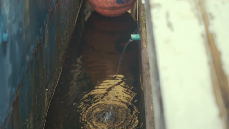 Water-being-pumped-out-of-bilge-in-wooden-boat