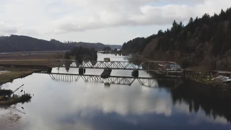 vintage-arched-railbridge-over-large-Siuslaw-river-on-Cushman-town,-Oregon