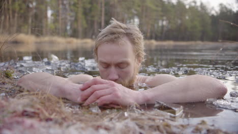 An-ice-bather-focuses-on-conscious-breathing-as-he-sits-in-a-frozen-lake