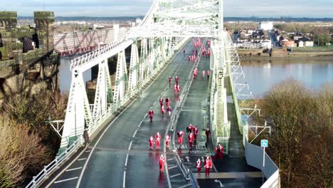 Wohltätigkeit-Santa-Dash-Spaßlauf-über-Runcorn-Silberjubiläumsbrücke-Luftbild-Langsam-Steigend