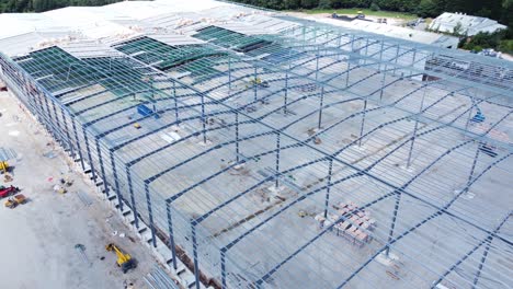 Construction-industry-metal-iron-girder-warehouse-framework-construction-site-aerial-view-dolly-right-slow