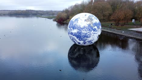 Luke-Jarram-floating-earth-exhibition-aerial-view-at-Pennington-flash-park-lake-slow-left-rotation