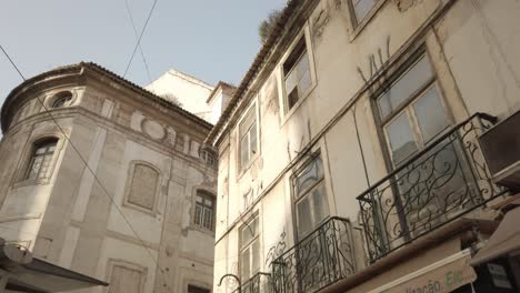 POV-Walking-Looking-Up-At-Lisbon-Buildings-With-Balconies