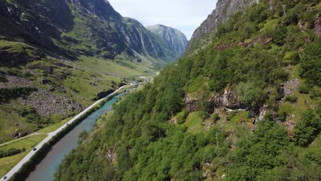 Los-Turistas-Viajan-A-Través-Del-Valle-De-La-Montaña-Para-Llegar-Al-Norte-De-Noruega---Antena-Stardalen-E-39-Noruega---Vista-Desde-La-Ladera-De-La-Montaña