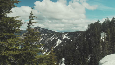 WIde-shot-of-the-trees-and-snow-on-the-slope-down-to-Crater-Lake-in-Oregon