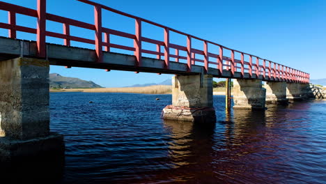 Famous-red-bridge-stretching-over-lagoon,-Kleinmond,-South-Africa