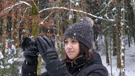 Beautiful-woman-do-nature-photography-in-forestry-area-during-snowfall